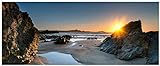 Wallario Glasbild Sonnenuntergang hinter einem Felsen am Strand - 50 x 125 cm Wandbilder Glas in Premium-Qualität: Brillante Farben, freischwebende Optik